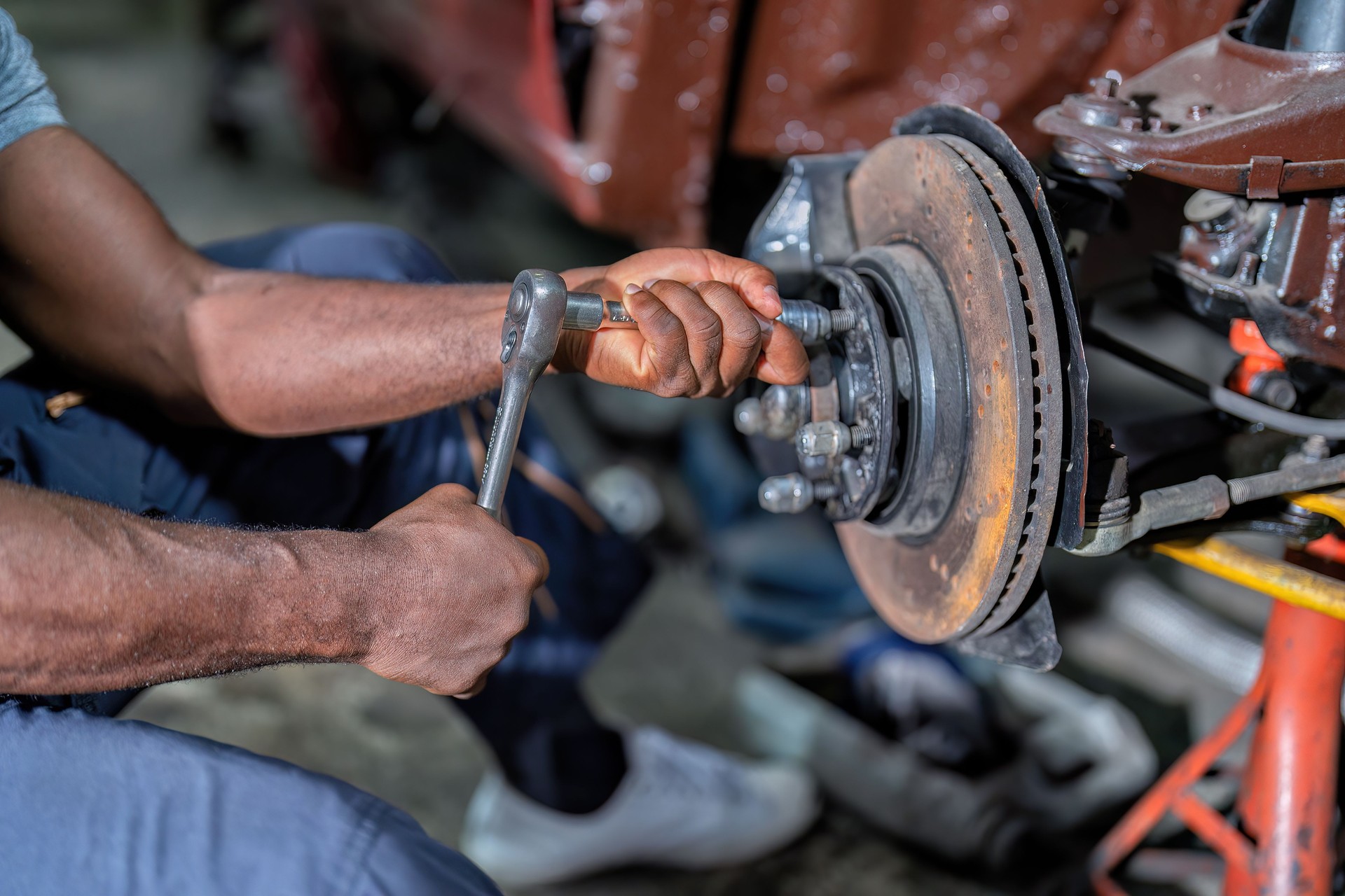 Mechanical man sitting concentrate use wrench to repair car